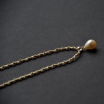 Lašo formos perlo pakabukas ant šilkinės juostelės Lašo formos perlo pakabukas ant šilkinės juostelės