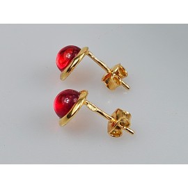 apvalūs Maži auksiniai auskarai vinukai su raudonu gintaru auskarai prie ausies.