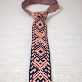 Austas rankomis tamsiai mėlynas kaklaraištis su rožinės spalvos ornamentais