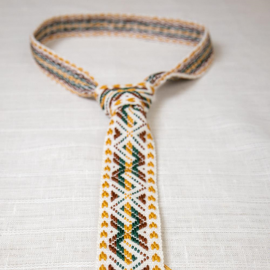 Austas rankomis šviesus kaklaraištis su baltų simboliais