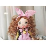 Dovana mergaitei lėlė, pagaminta iš audinio rausvu kombinezonu ir geltonu triušiu.